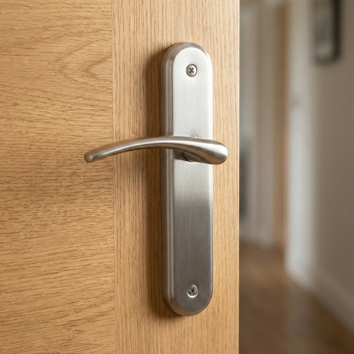 Manilla modelo '6331' de zamak con placa ovalada en acabado níquel satinado para puertas